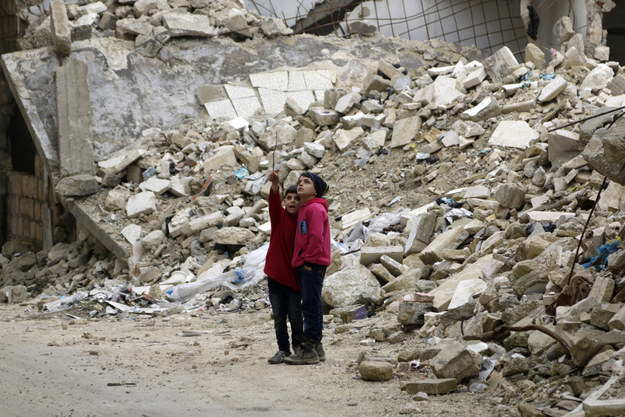 کودکانی که آسیب‌های وارده به ساختمان‌ها را در استان ادلب سوریه بررسی می کنند. ۲۱ ژانویه ۲۰۱۵